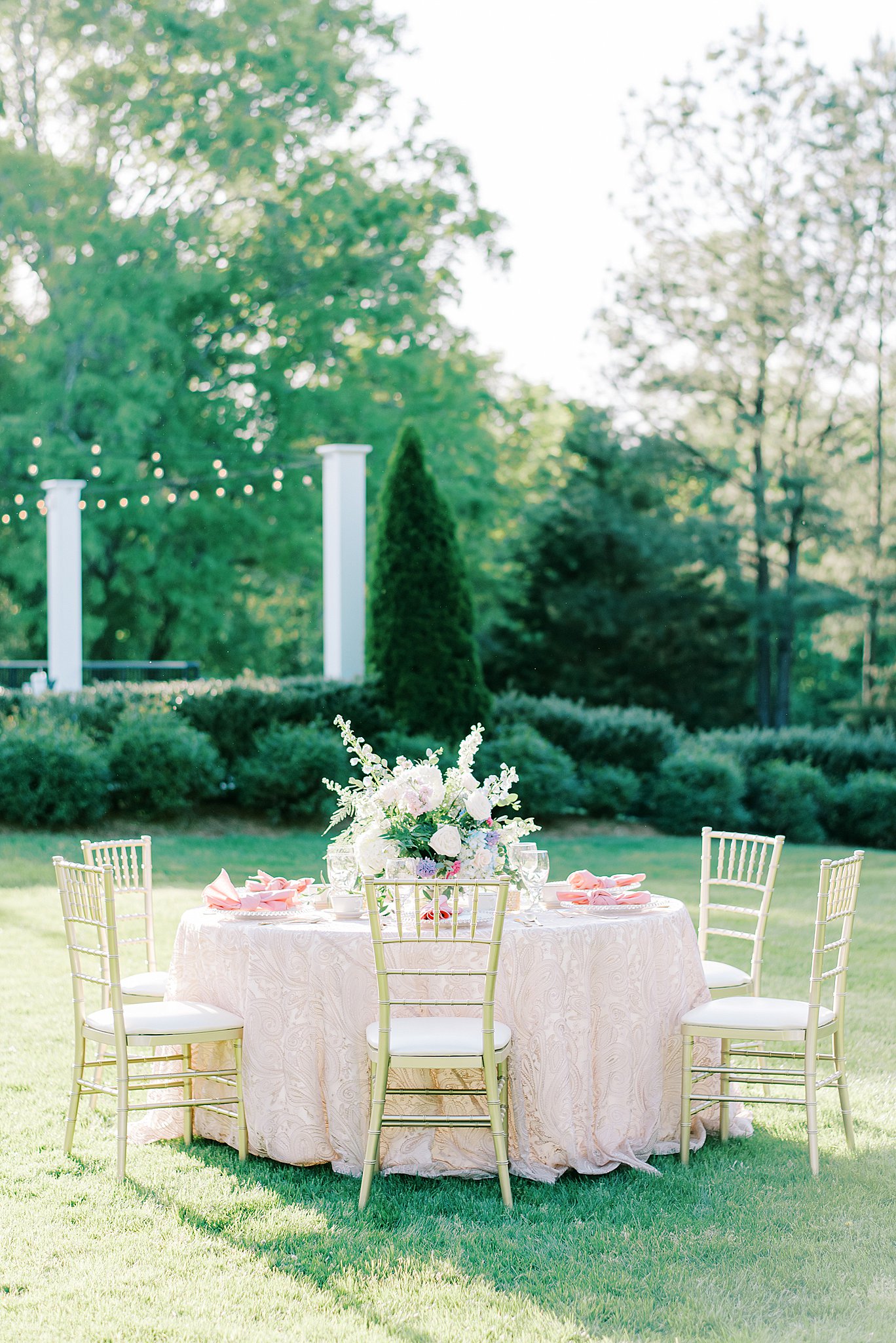 Details of an outdoor wedding reception table set up with pink linen Camellia Gardens