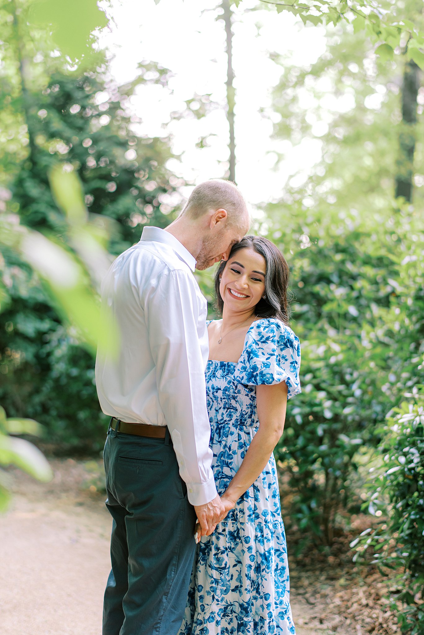 Newlyweds embrace while in a thick garden path