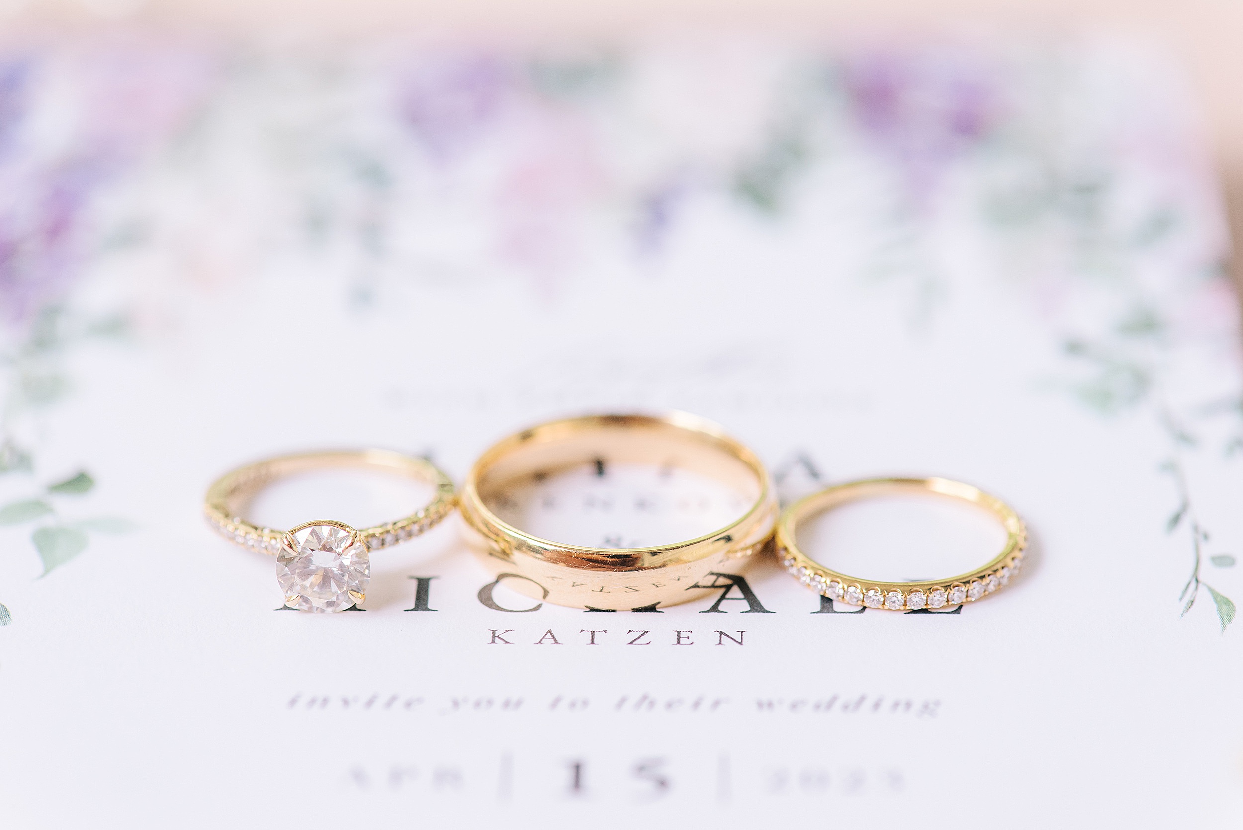 Details of three wedding bands sitting on an invitation