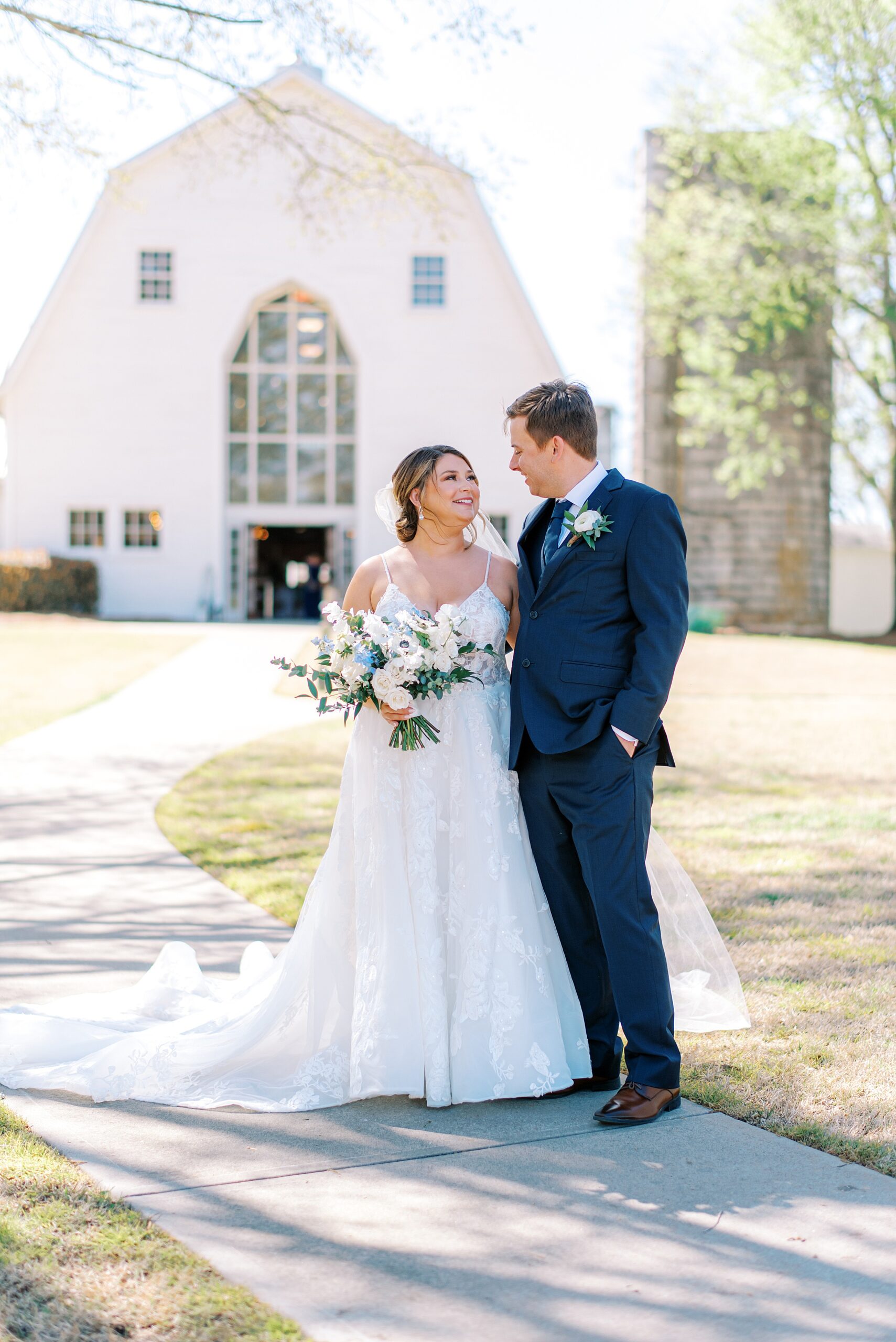 Newlyweds walk down a sidewalk together at a farm wedding venues in charlotte nc