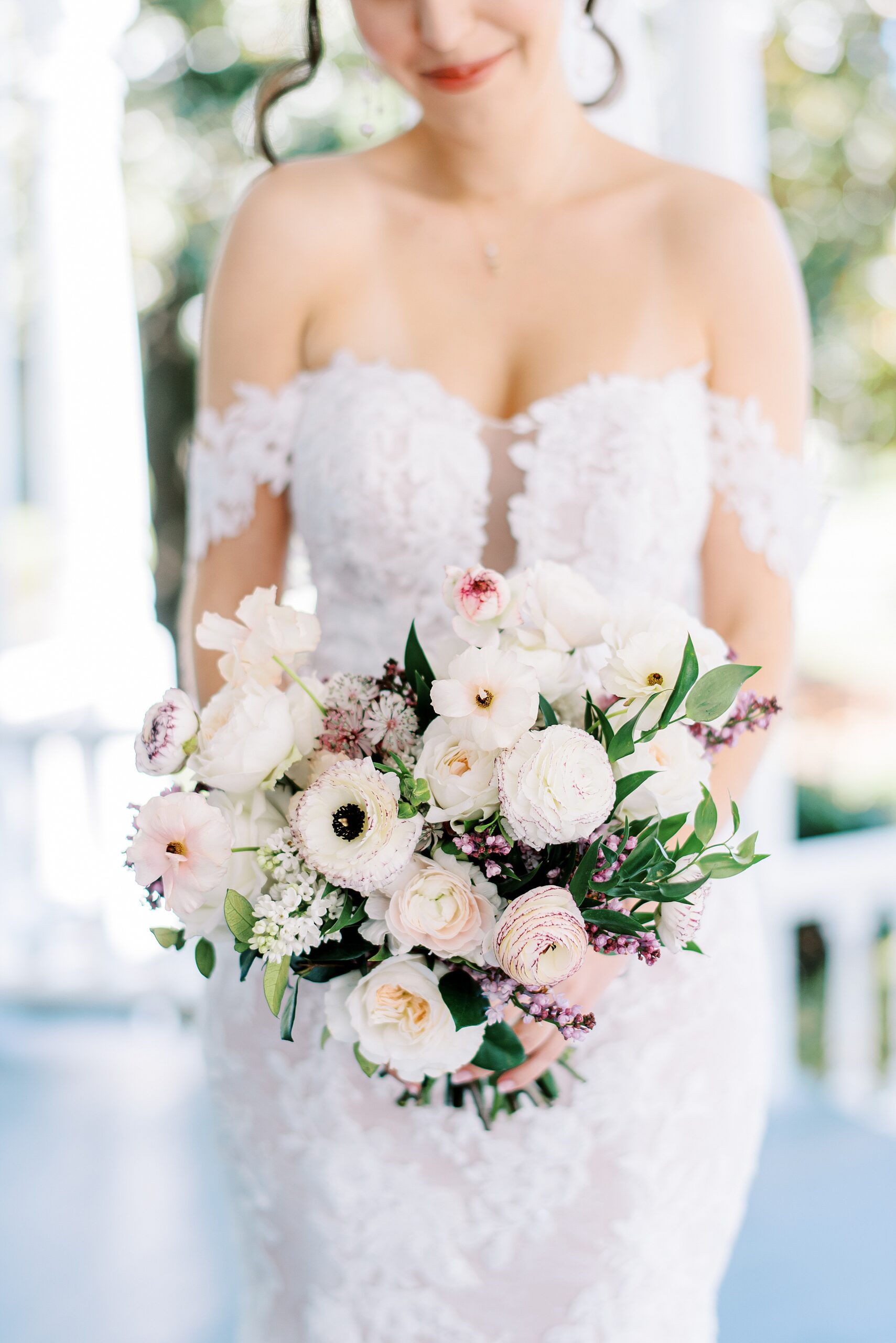 Details of a bride in a lace dress holding her bouquet in front of her unique wedding venues in charlotte nc